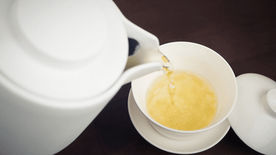 Pouring tea from the Duo Pot with a dripless spout into a cup, showcasing its award-winning design for efficient brewing.